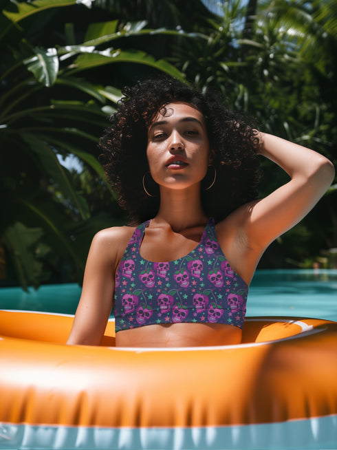 Two-piece bikini set featuring a bold pastel goth design with neon pink skulls wearing green bows, surrounded by multicolored stars on a deep black background. The set includes a plunging V-neck bikini top with wide straps and high-waisted bottoms for a flattering retro fit. Made of stretchy, soft material with a smooth black lining. This skull print swimsuit is ideal for alternative, edgy summer style with a playful punk twist.